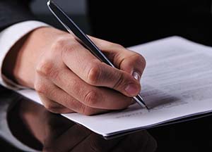 businessman writing on a form