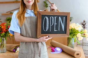 Florist Holding Open Sign